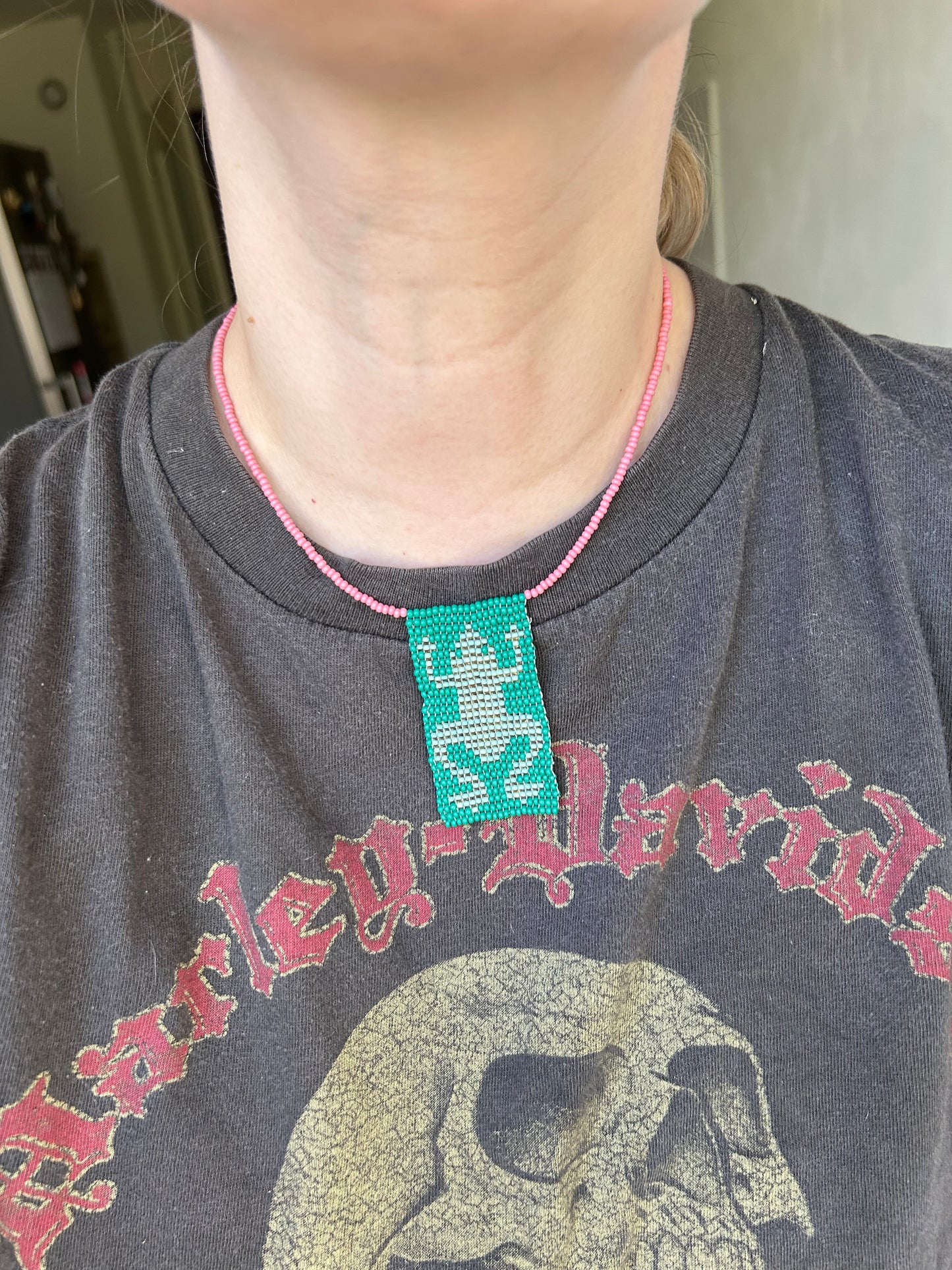 Beaded necklace with a frog pendant.